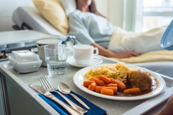 plate of food next to a hospital bed